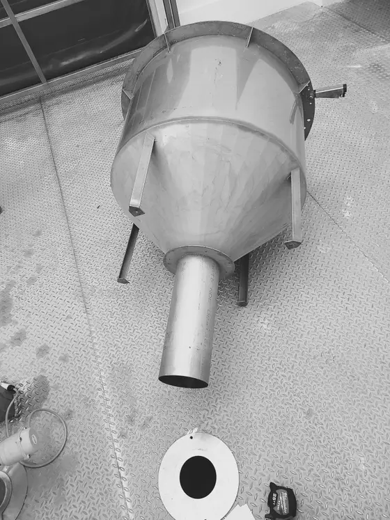 Custom stainless steel conical hopper tank with outlet spout fabricated by Wetzel Welding