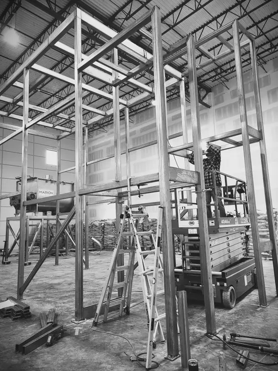 Multi-level structural steel mezzanine platform fabricated by Wetzel Welding in a warehouse