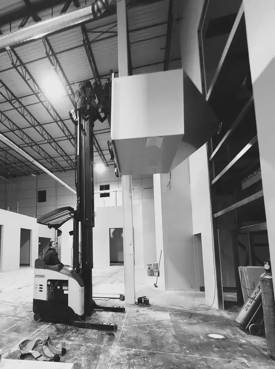 Wetzel Welding installing a large fabricated enclosure using a reach forklift